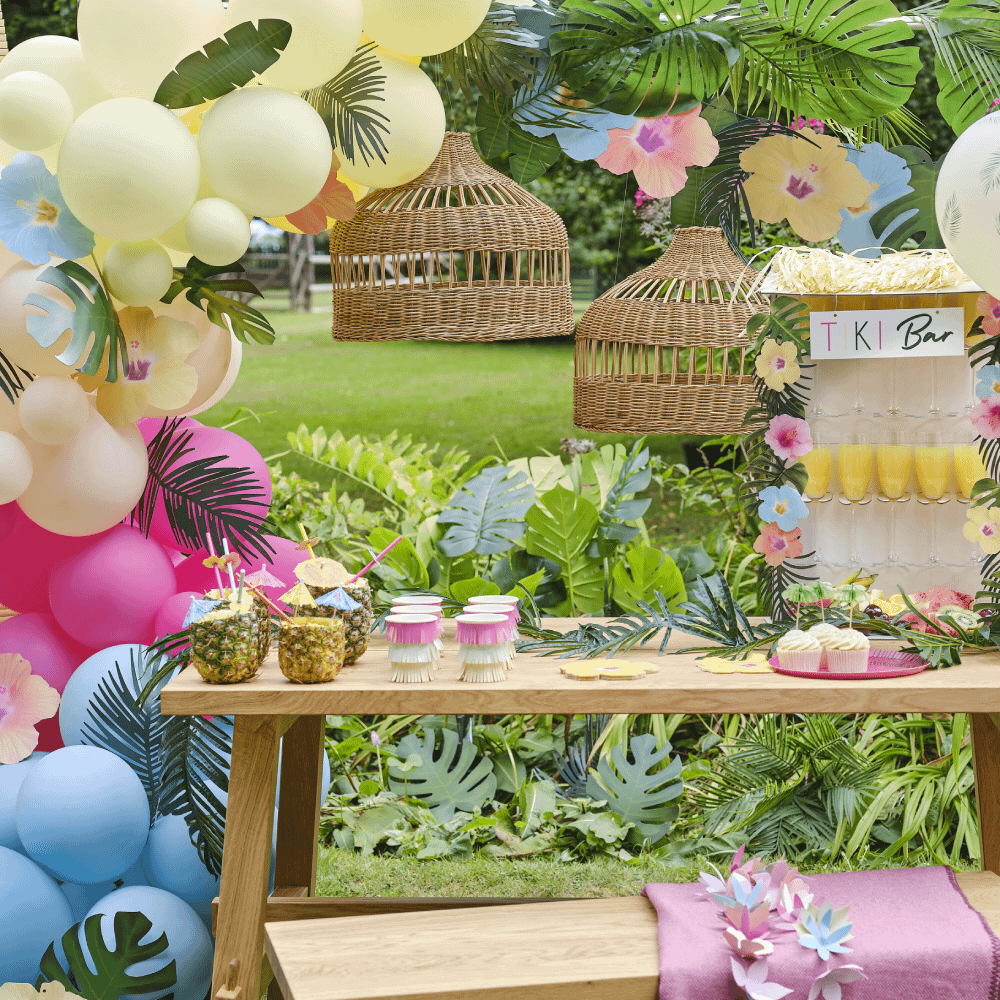 Tropische feestversiering met ballonnen en groene bladeren en een tiki bar