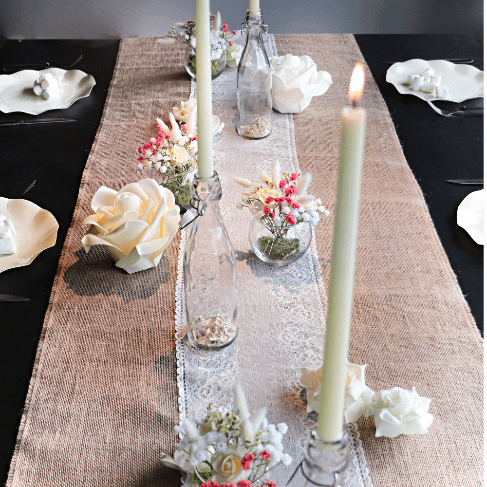 tafel met witte tafelloper, groene kaarsen en witte rozen