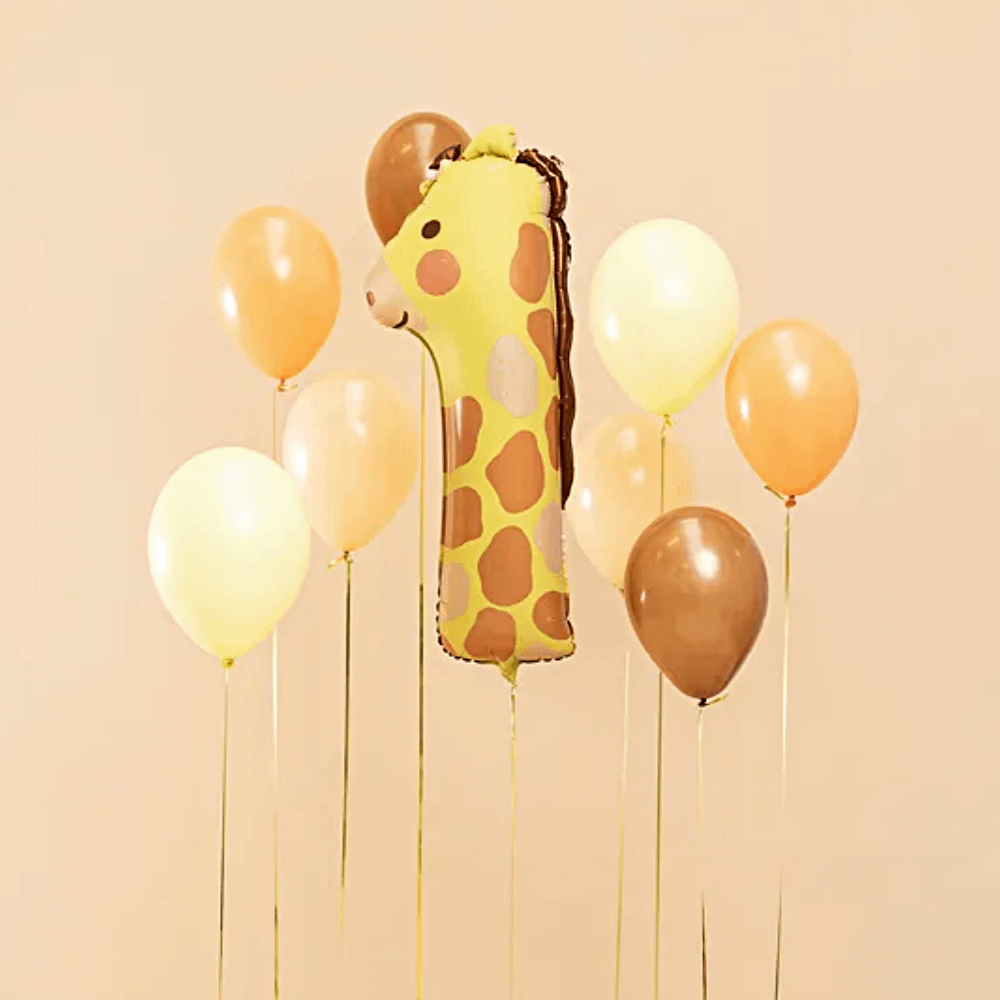 ballon cijfer 1 met giraffeprint zweeft voor een oranje muur naast bruine en beige ballonnen gevuld met helium