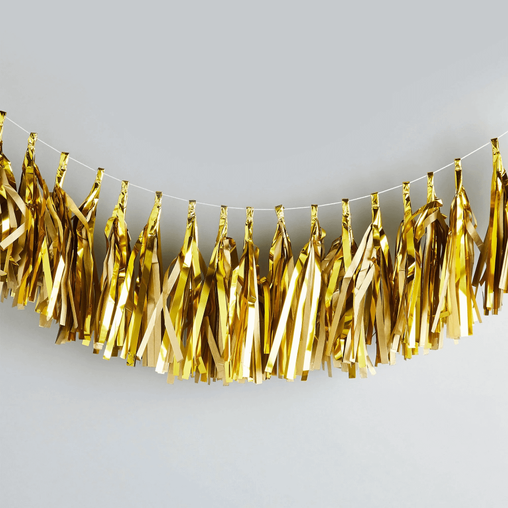gouden tassel slinger hangt voor een grijze muur