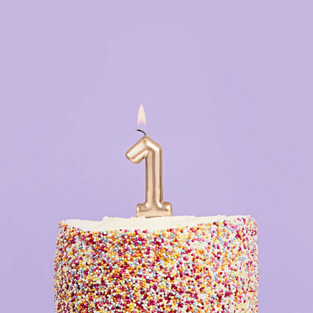 gouden cijfer 1 in een regenboog taart voor een paarse achtergrond