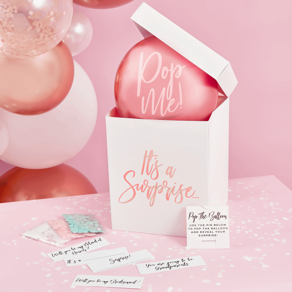 witte doos met roze en rose gouden tekst en een chrome ballon