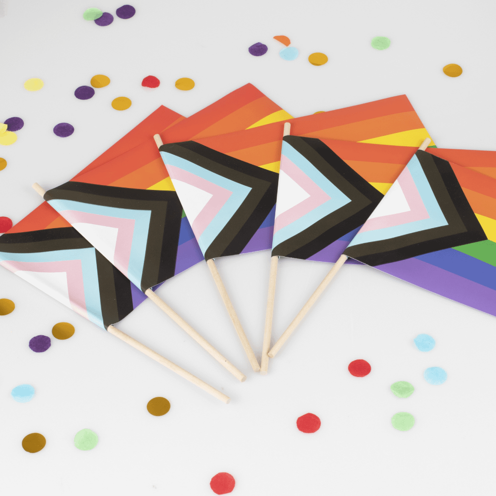 regenboog pride vlaggetjes op een witte ondergrond omringd door ronde regenboog confetti