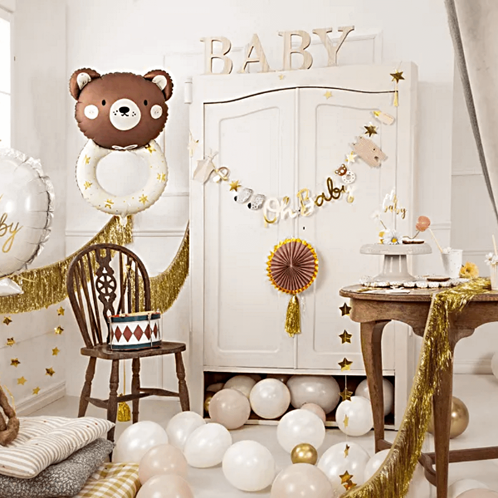 babykamer met houten en bruine versiering zoals ballonnen, een slinger en houten letters baby