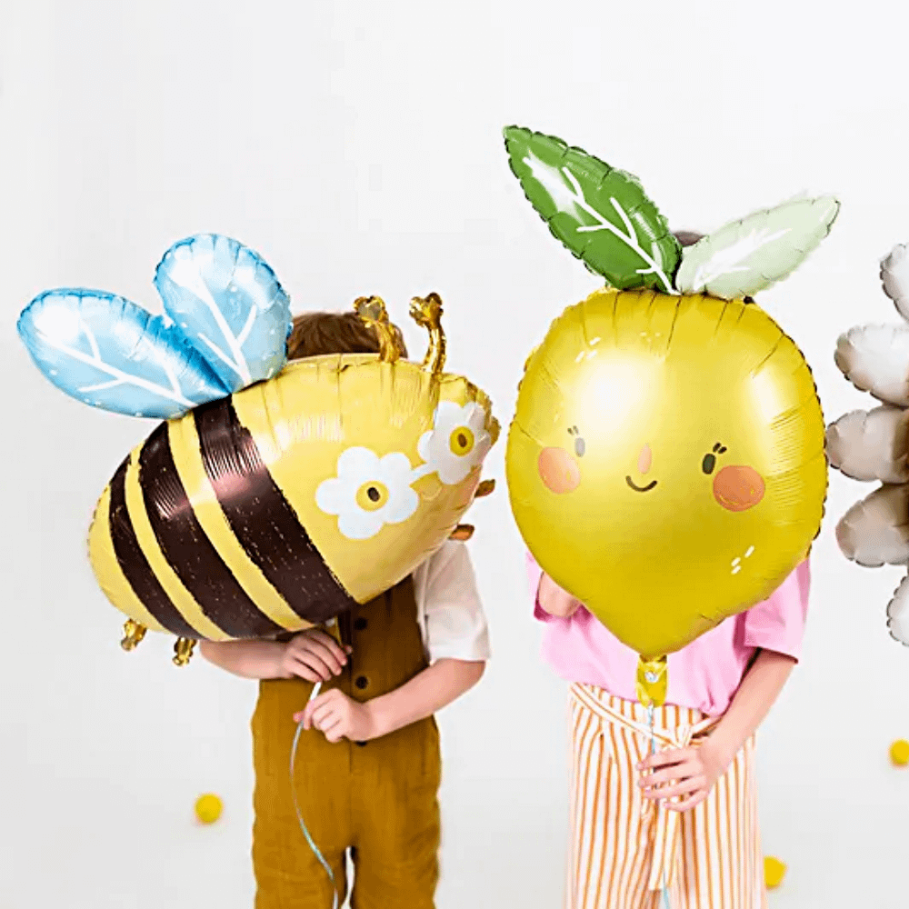 kinderen met folieballonnen in de vorm van een hommel, een citroen en een zonnetje