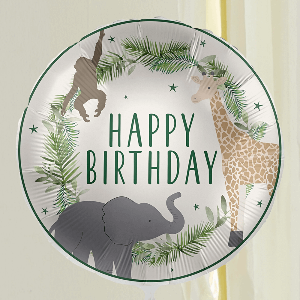 folieballon met een giraffe, aapje en olifant en de groene tekst happy birthday en palmbladeren zweeft in een kamer
