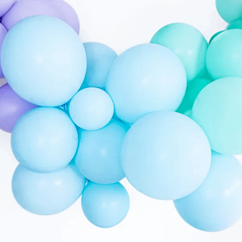 pastel blauwe ballonnen in een ballonnenboog naast paarse en mint ballonnen