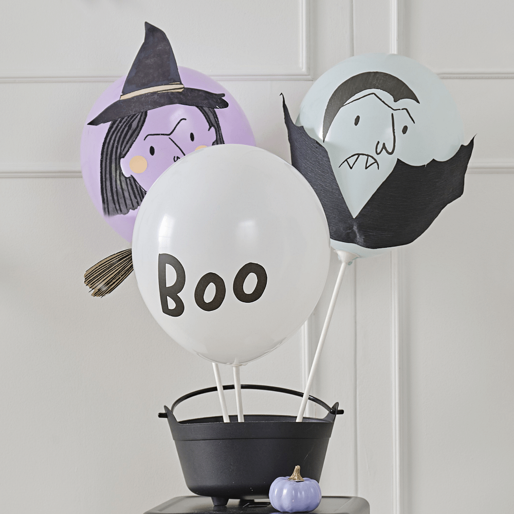 Lila, mintgroene en witte ballon bedrukt met de tekst boo, een heksengezicht en een vampier zitten in een zwarte hekselketel