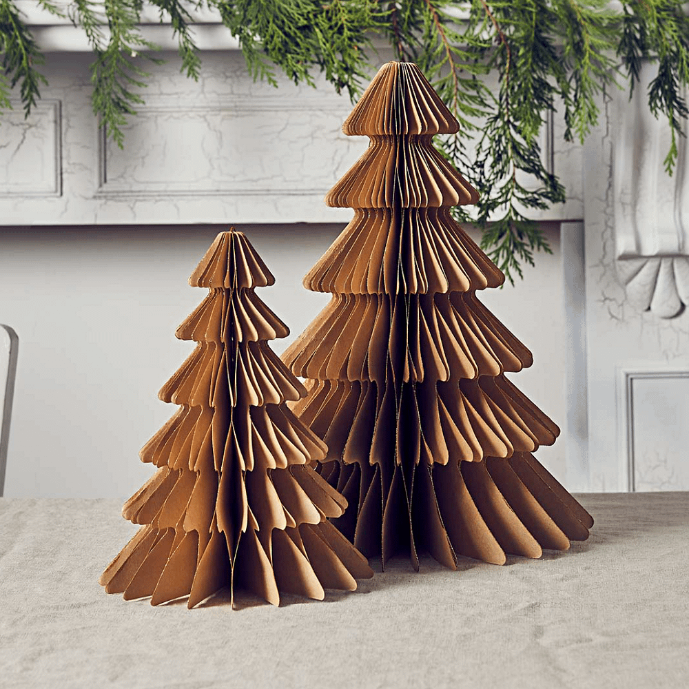 Honeycomb kerstbomen van kraft papier met gouden glitterrand staan op een katoenen kleed