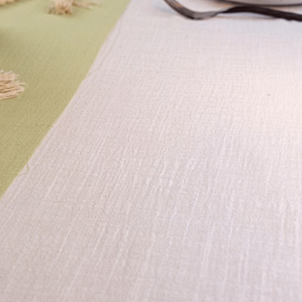 Wit katoenen tafelkleed met een saliegroene tafelloper