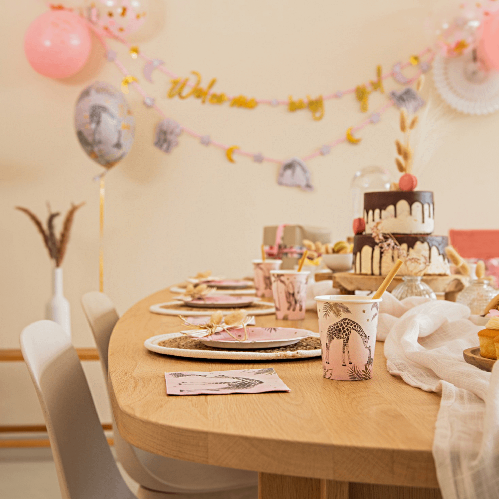Verisiering van een tafel voor een babyshower met roze en gouden safari versiering