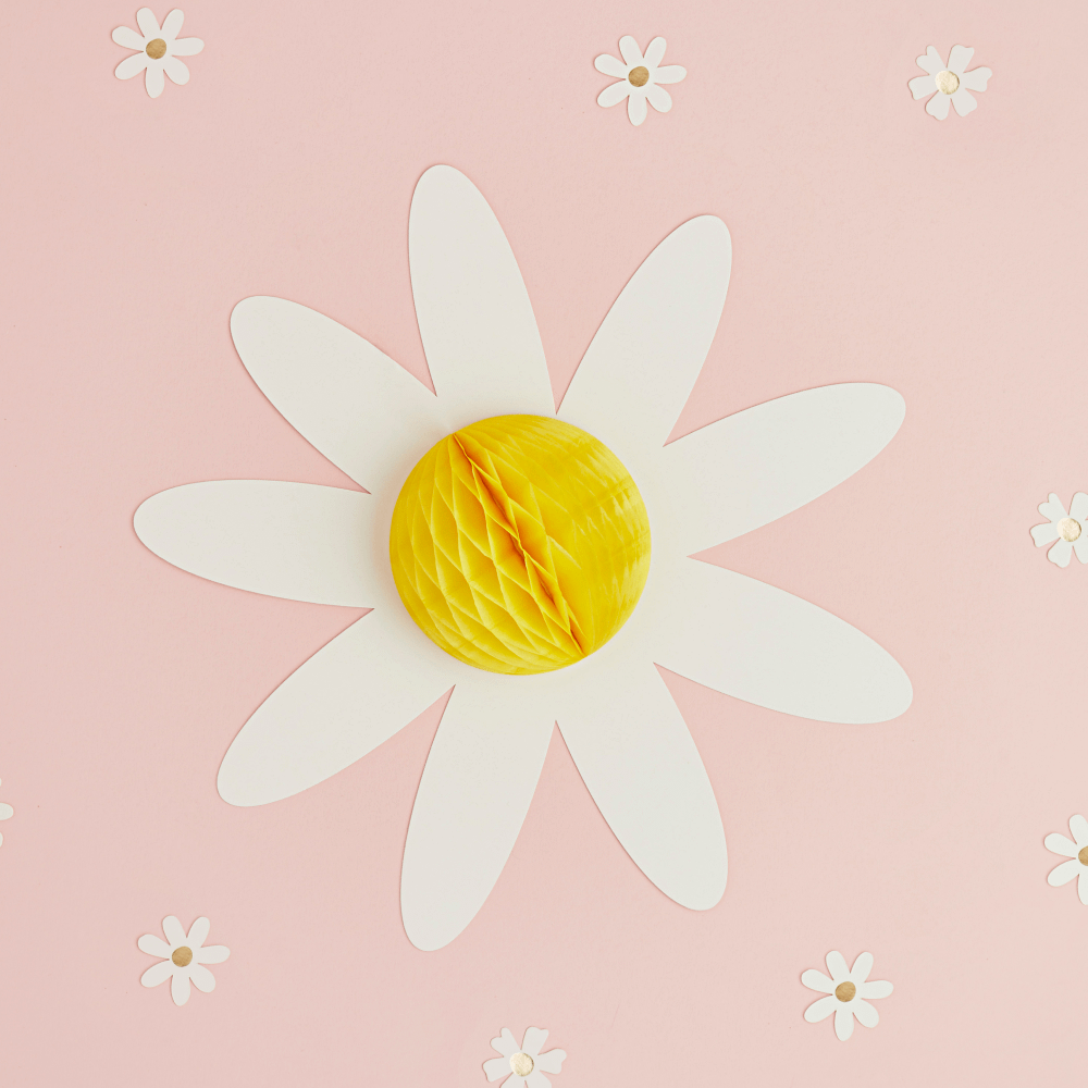 Gele honeycomb met witte blaadjes van een madeliefje op een roze achtergrond