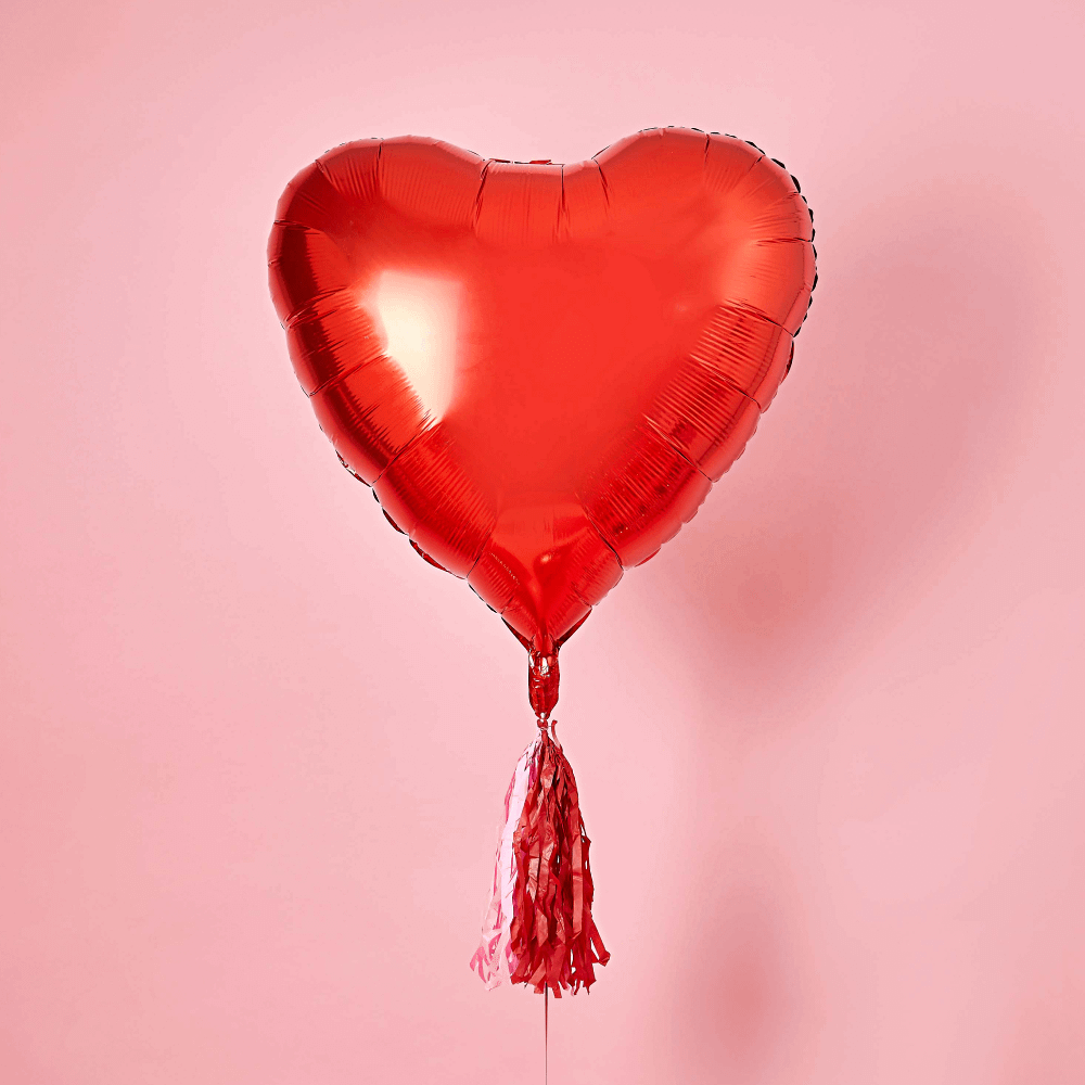 rode ballon in de vorm van een hart op een roze achtergrond