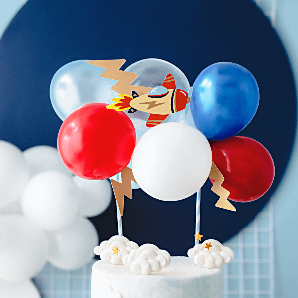 mini ballon versiering met vliegtuig thema staat op een taart