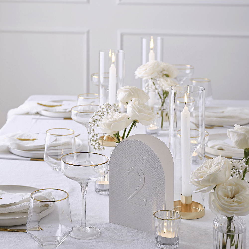 Gouden en witte tafel versierd met glazen met een gouden rand en witte rozen