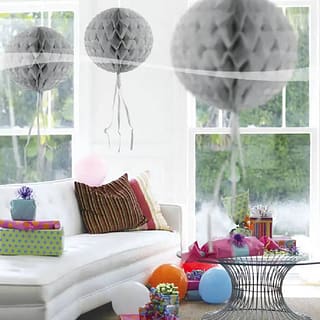 Drie zilveren honeycombs in een kamer met ballonnen en cadeaus