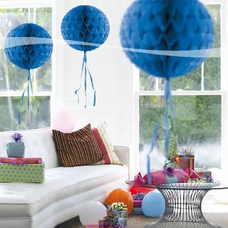 Drie donkerblauwe honeycombs in een kamer met cadeaus en ballonnen