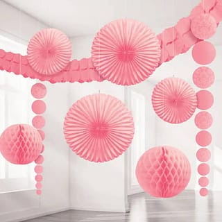Roze honeycombs waaiers en slingers in een kamer