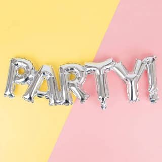 Zilveren folieballonnen spellen het woord 'party' op een gele met roze achtergrond