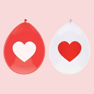 Witte en rode latexballonnen met witte en rode hartjes op lichtrode achtergrond