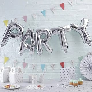Folie ballon in de vorm van het woord Party met daaronder een feestelijke tafel