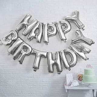 Folie ballon in de vorm van de woorden Happy birthday aan de muur
