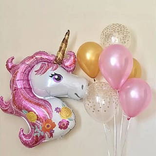 Unicorn folieballon met daarnaast een ballonnenbundel met roze en gouden ballonnen