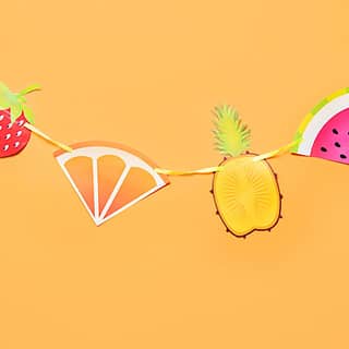 Fruitslinger met een aardbei, sinaasappel, ananas en watermeloen aan een lijn