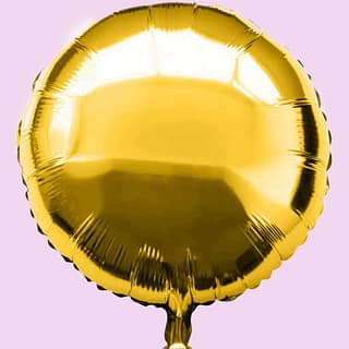 Gouden folieballon op lichtroze achtergrond