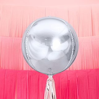 Zilveren ronde folieballon voor een roze achtergrond