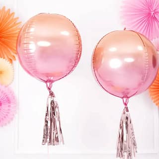 Roze en oranje ballonnen met een rose gouden tassel eronder