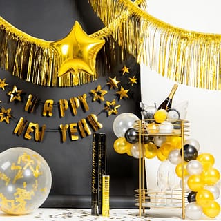 Gouden nieuwjaarsversiering met gouden franjeslingers, een gouden confettiballon en party poppers