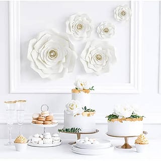 Sweet table met taart en macarons en witte rozen decoratie op de muur