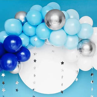 Ballonnenboog van blauwe zilveren en witte ballonnen met daarachter een wolk en zilveren sterren slingers