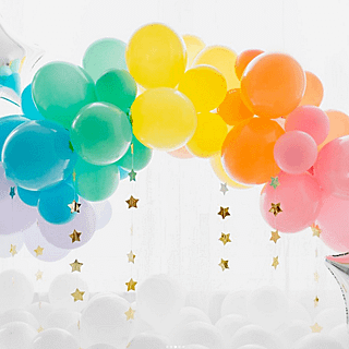 Pastel ballonnenboog in het geel, oranje, roze, groen, wit en blauw met gouden sterren