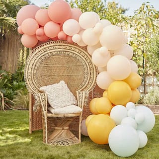 Ballonnenboog in doffe pastel tinten met rotan stoel