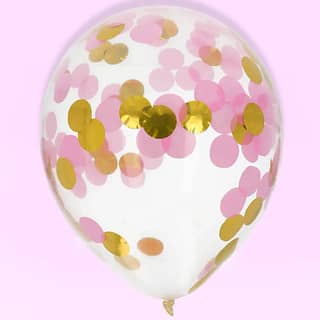 Confettiballon met gouden en roze confetti op een lichtroze achtergrond