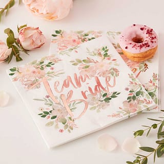 Witte servetten met bloemen en de tekst team bride in rosé goud