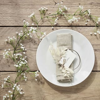 Tafel met bordje met servet en een streng met witte bloemetjes