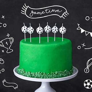 Groene taart met daarop zes kaarsen met voetballetjes eraan
