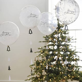 Confetti ballonnen met merry christmas erop en kerstboom ballonstaart eronder in kamer met kerstboom
