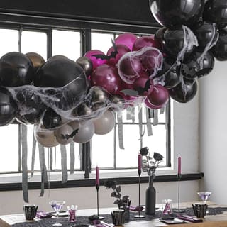 Ballonnenboog in halloween stijl met vleermuizen erop boven gedekte tafel