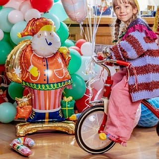 Folieballon Kerstman op houten vloer met meisje op fiets