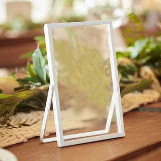 Wit foto frame op tafel met groene bladeren