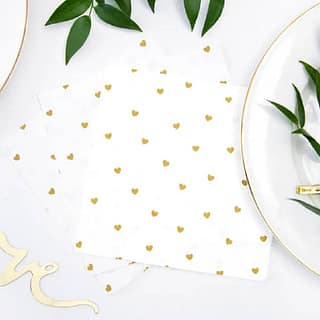 Witte servetten met gouden hartjes op tafel