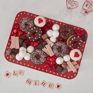 Hapjesplank rood met roze hartjes gevuld met donuts, cupcakes en snoepjes
