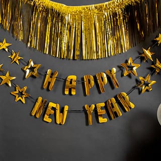 Gouden slinger tegen een zwarte muur met de tekst happy new year