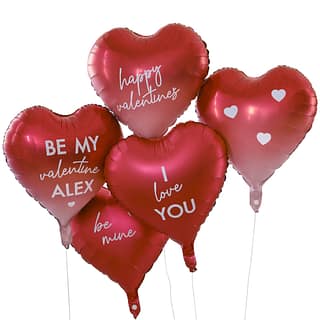 Rode ballonnen met witte tekst voor een witte muur met rode en roze hartjes