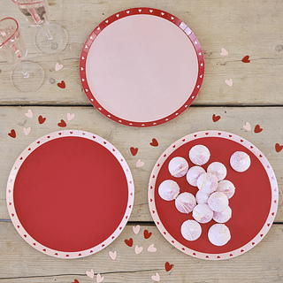 Rood en roze bordjes met hartjes op een houten tafel versiering met hartvormige confetti