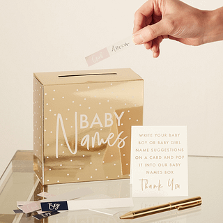 Gouden doosje met de tekst 'baby names' en een gouden pen met witte kaartjes
